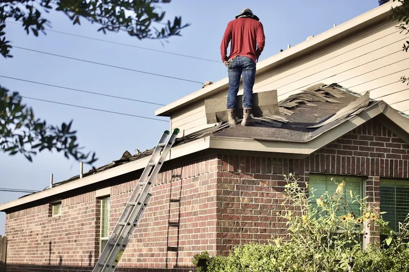 Professional roofer working on a residential roof in Carle Place